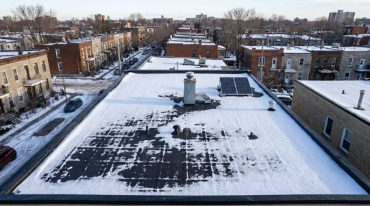 Vue aérienne d'un toit plat résidentiel à Montréal recouvert de membrane élastomère après une chute de neige hivernale